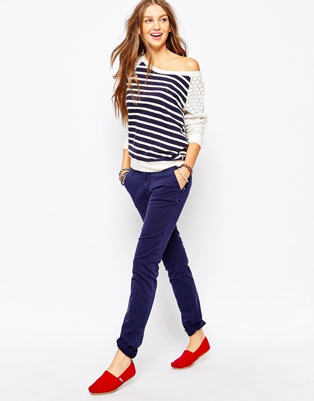 model posing with striped shoulder-less long sleeve shirt, blue denim jeans and red shoes